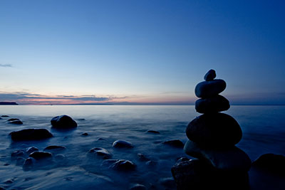 blaue Sunde am Strand mit Steinpyramide